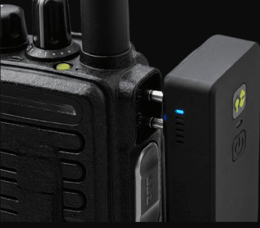 QuickComm dongle aligning with a professional handheld radio