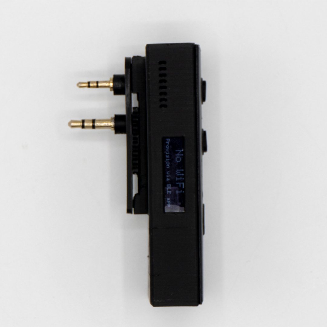 Side profile of the QuickComm Bridge Node showing the twin gold audio plugs and the edge-mounted status display