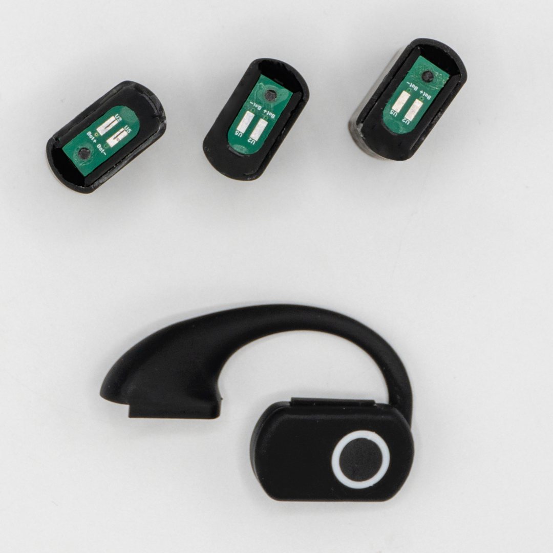 Three hot-swap battery packs laid out above the QuickComm Earpiece hook